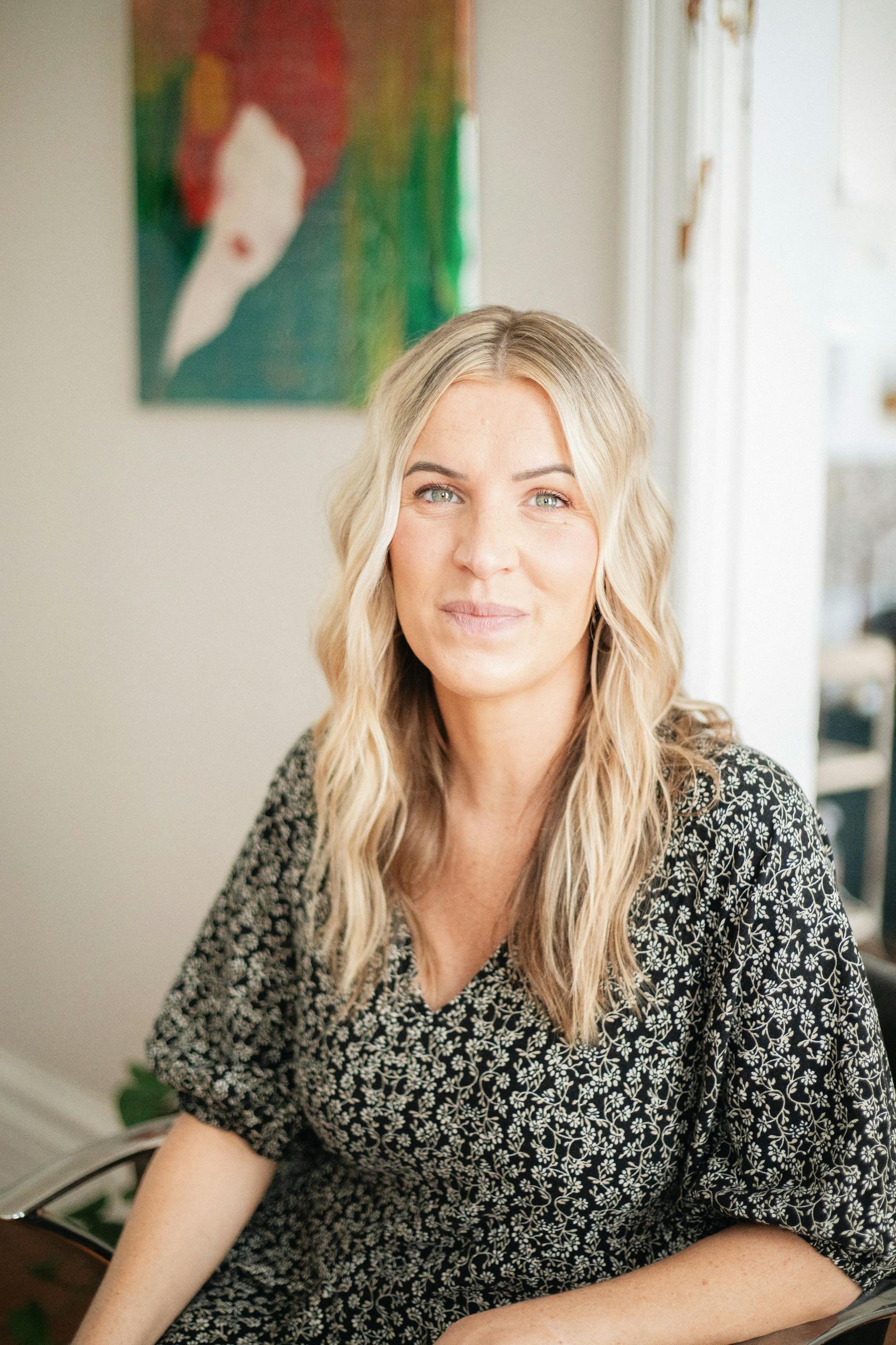 Candid portrait of a female hairstylist in a salon setting, showcasing natural beauty and professionalism.